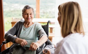 Sundale staff member chatting warmly with a senior resident in a Queensland retirement village garden 
