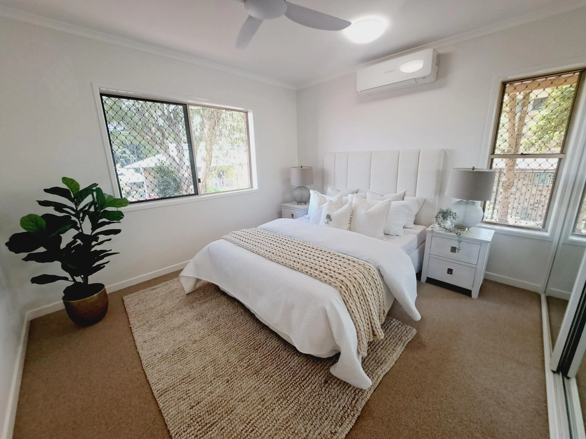 Bright bedroom in retirement community, featuring cozy furnishings and natural light.